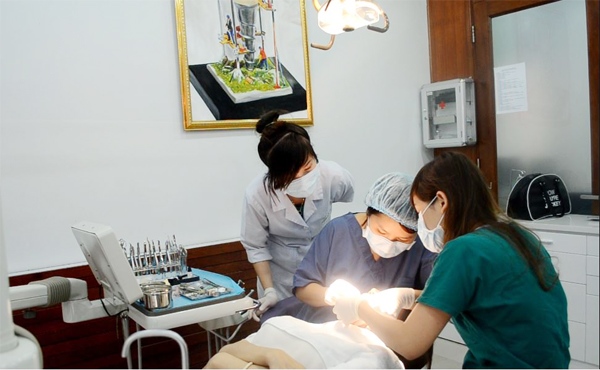 Bác sĩ vệ sinh răng miệng cho bệnh nhân trước khi bọc răng sứ- Nguồn: Nha khoa Úc Châu